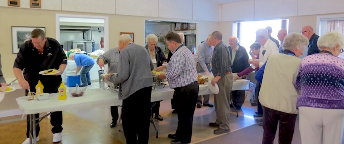A hungry bunch of Power Pioneers lined up for food as each of their tables was called.